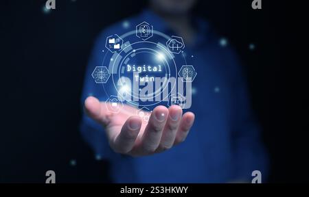 Concetto di doppio digitale. Tecnologia di automazione della produzione industriale. Un uomo con icone gemelle digitali in mano. Foto Stock