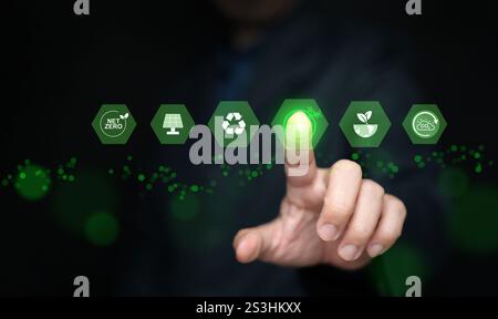 Concetto di energia verde. Un uomo attiva o tocca icone di fonti di energia rinnovabili sostenibili Foto Stock