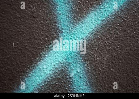 Vernice spray blu a forma di x su pareti ruvide Foto Stock