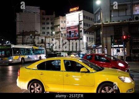 Taxi nel traffico stradale nel porto del Pireo di notte ad Atene capitale della Grecia nella regione Attica il 13 gennaio 2024. Taxi dalla circul Foto Stock