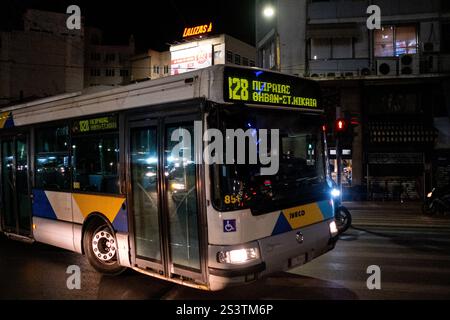 Autobus nel traffico stradale nel porto del Pireo di notte ad Atene capitale della Grecia nella regione Attica il 13 gennaio 2024. Bus dans la circolat Foto Stock