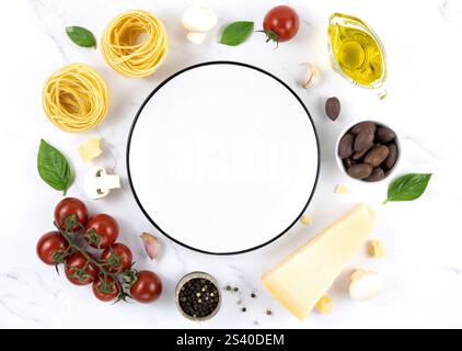Ingredienti per cucinare pasta, spaghetti, tagliatelle, olive, pomodori, formaggio, olive su sfondo bianco. Foto Stock