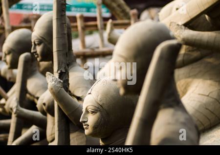 Un esperto artigiano forma meticolosamente l'argilla in una splendida scultura in un vivace laboratorio pieno di creazioni artistiche. La luce calda del sole. Foto Stock