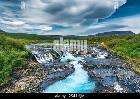 Splendida e vivace cascata bruarfoss panoramica che scorre attraverso rocce e natura selvaggia in estate nell'area Golden Circle, Islanda Foto Stock