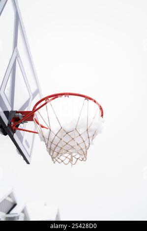 Canestro da basket coperto di neve durante l'inverno in un quartiere periferico Foto Stock