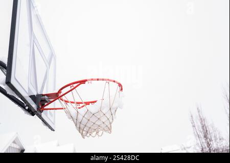 Canestro da basket coperto di neve durante l'inverno in un quartiere periferico Foto Stock