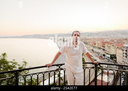 Uomo che posa al punto panoramico al tramonto su Nizza, Costa Azzurra Foto Stock