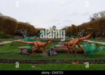 Esposizione dettagliata di sculture di dinosauri in un giardino lussureggiante durante una giornata nuvolosa Foto Stock
