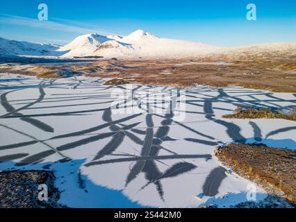 Rannoch Moor, Scozia, Regno Unito. 10 gennaio 2025. Temperature inferiori allo zero nelle Highlands scozzesi causano il congelamento dei piccoli laghi di Rannoch Moor vicino a Glencoe, creando un bellissimo paesaggio invernale. FIG. Vista aerea dal drone di schemi astratti causati dal ghiaccio su Lochan na h-Achlaise. Iain Masterton/Alamy Live News Foto Stock