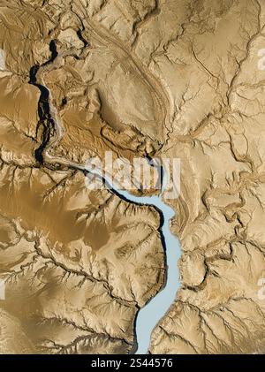 Veduta aerea di un fiume tortuoso che attraversa terreni crepati e aridi, mostrando motivi intricati e toni terrosi nel paesaggio unico dell'Islanda. Foto Stock