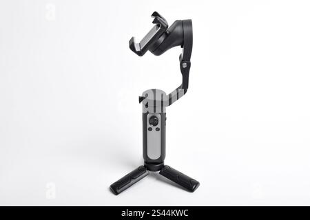 Stabilizzatore cardanico per smartphone isolato su sfondo bianco. Moderno stabilizzatore-gimbal per riprese foto-video. Gadget per blogging, streaming, video Foto Stock