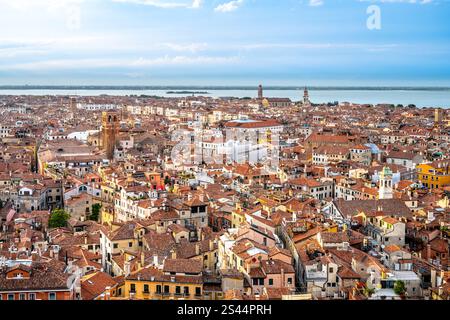 I pittoreschi tetti di Venezia mostrano un labirinto di piastrelle di terracotta e architettura storica, riflettendo il ricco patrimonio culturale della città sotto un cielo blu luminoso lungo i canali. Foto Stock