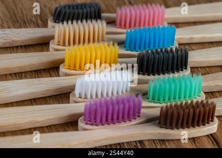 Set di spazzolini in bambù multicolore su sfondo in legno, primo piano. Zero sprechi, senza plastica, concetto di prodotto biologico ecologico Foto Stock