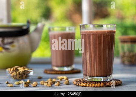 Masala chai indiano o tè in due bicchieri con bollitore sul davanzale, primo piano Foto Stock