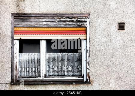 Facciata della vecchia casa, finestra con persiane rotte e tendaggi logori, Germania, Europa Foto Stock
