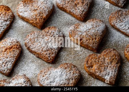 Biscotti fatti in casa a forma di cuore sul vassoio da forno, primo piano Foto Stock
