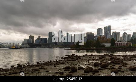 Il centro di Vancouver e l'isola Deadman visti da Stanley Park attraverso Coal Harbour in una giornata nuvolosa, British Columbia, Canada. Foto Stock