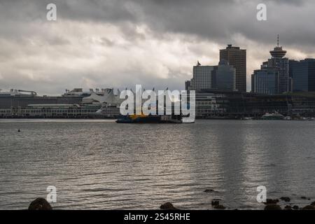 Skyline del centro di Vancouver attraverso Coal Harbour visto da Stanley Park in una giornata nuvolosa nella British Columbia, Canada. Foto Stock