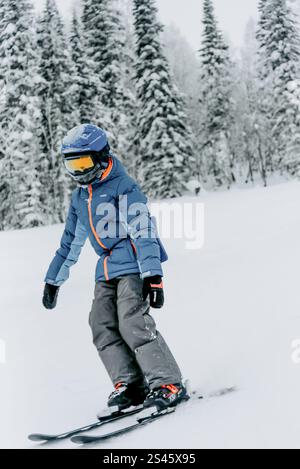 Snowboarder che scivola su una pista innevata, motociclisti che si rilassano in una stazione sciistica, sport estremi Foto Stock
