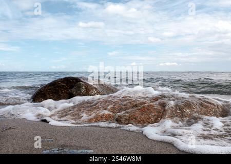 Pietre e onde sulla spiaggia del Mar Baltico Foto Stock