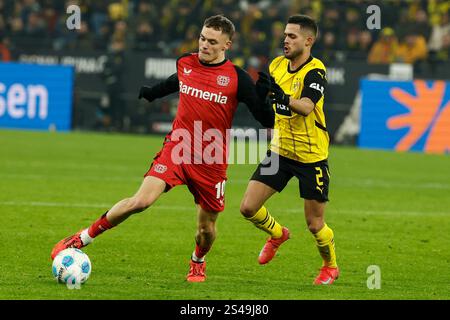 Dortmund, Germania. 10 gennaio 2025. Yan Couto (R) del Borussia Dortmund vies con Florian Wirtz del Bayer 04 Leverkusen durante la partita di prima divisione di Bundesliga tra il Borussia Dortmund e il Bayer 04 Leverkusen a Dortmund, Germania, 10 gennaio 2025. Crediti: Joachim Bywaletz/Xinhua/Alamy Live News Foto Stock