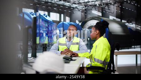 Uomo e donna che lavorano nella generazione di energia elettrica delle centrali elettriche Foto Stock