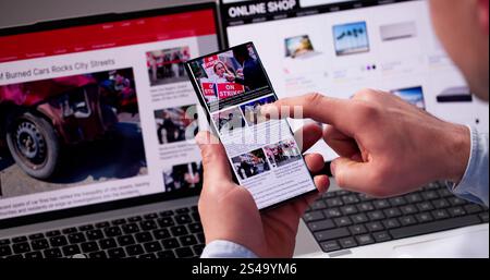 Guardare l'articolo di notizie in linea sul telefono mobile e sul laptop. Giornale elettronico Foto Stock