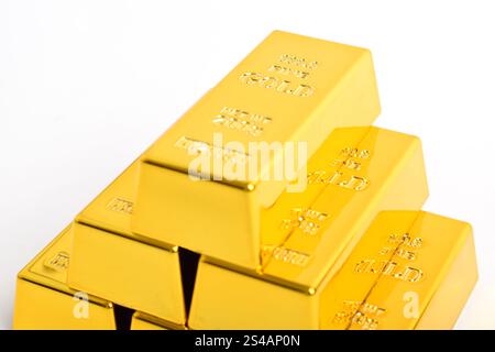 Pila di barre dorate lucide isolate su sfondo bianco, primo piano Foto Stock