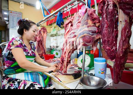 Ho chi Minh City, Vietnam - 23 gennaio 2018: Macellaio vietnamita che lavora e taglia la carne in una bancarella del mercato di Ben Thanh Market, ho chi Minh Cit Foto Stock