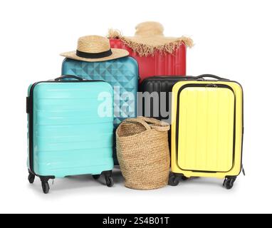 Molte valigie colorate, borsa da spiaggia e cappelli di paglia isolati su bianco Foto Stock