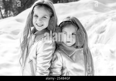 Due ragazzine che giocano con la neve nel parco. Ritratto invernale per bambini. Due adorabili ragazze che si divertono insieme nel bellissimo parco invernale. Sorelle carine Foto Stock