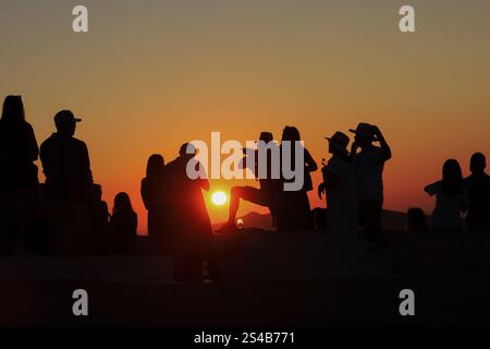 Figure sagomate, folla serale che guarda il tramonto a Oia, Santorini, Grecia – 27 settembre 2023 Foto Stock