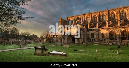 Malmesbury, Wiltshire, Inghilterra - gli ultimi raggi del sole invernale illuminano la storica abbazia nella cittadina di Malmesbury, in collina, nel Wiltshire. Foto Stock