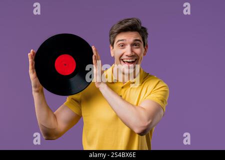 Bell'uomo maturo che balla con disco in vinile su viola. Hobby, amante della musica, collezione, stile di vita nostalgico. Foto di alta qualità Foto Stock