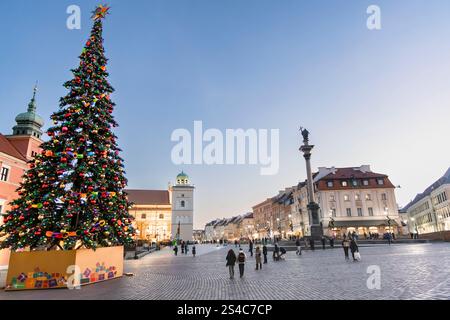 Una magica notte invernale in una piazza della città. L'albero di Natale splendidamente decorato è illuminato da migliaia di luci, creando un'atmosfera festosa Foto Stock