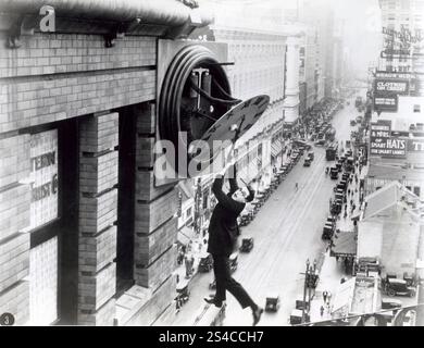 Il comico americano Harold Lloyd in una famosa scena tratta dal suo film Safety Last, in cui si aggira da un orologio su un grattacielo. Stati Uniti, 1923. Foto Stock