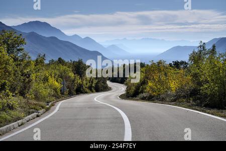 Tortuosa strada di campagna attraverso la foresta e le montagne della Bosnia ed Erzegovina Foto Stock