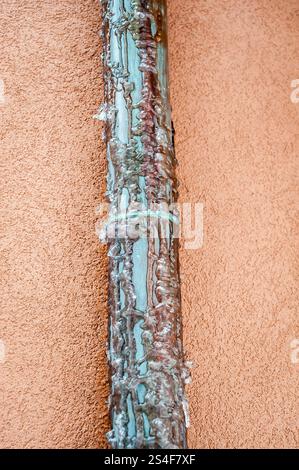 Tubo in rame congelato. Scarico dell'acqua dal tetto dell'abitazione. Foto Stock
