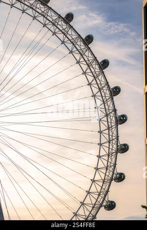 Una vista dettagliata del London Eye, che cattura la sua struttura intricata e le iconiche postazioni passeggeri durante un tranquillo tramonto Foto Stock