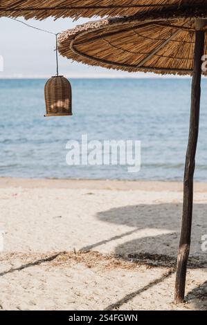 ombra sulla spiaggia con ombrelloni di paglia tazze e decorazioni rustiche Foto Stock