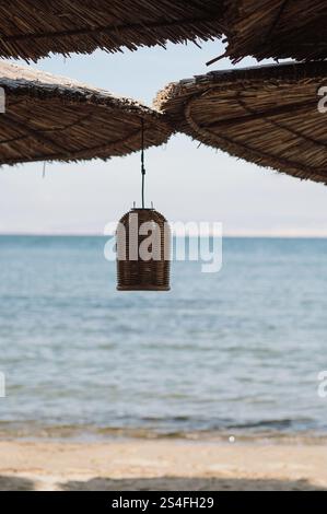 ombra sulla spiaggia con ombrelloni di paglia tazze e decorazioni rustiche Foto Stock