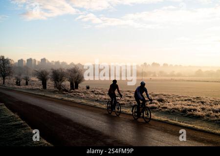 Ciclisti all'alba a Richmond Park, Londra. Gran parte del Regno Unito ha sopportato temperature al di sotto del congelamento durante la notte, mentre il freddo sprigiona in tutto il Regno Unito continua. Data foto: Domenica 12 gennaio 2025. Foto Stock