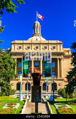 Un grande edificio con una grande bandiera in cima. L'edificio e' circondato da un grande prato con fiori e una torcia antincendio Foto Stock