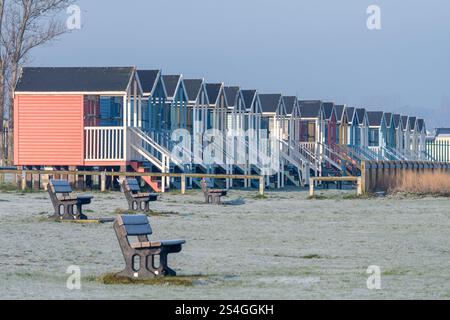 Capanne da spiaggia a Leysdown-on-Sea sull'isola di Sheppey, Kent, Inghilterra, Regno Unito, in una fredda e gelida mattina invernale Foto Stock