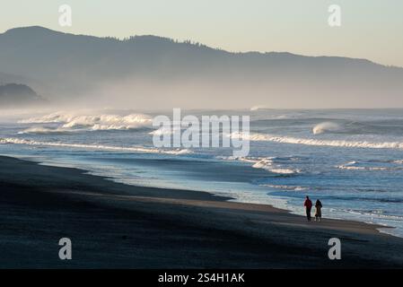 Una coppia che cammina a Kiwanda Beach, Oregon. Foto Stock