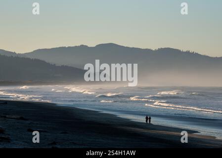 Una coppia che cammina a Kiwanda Beach, Oregon. Foto Stock