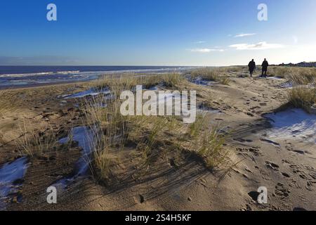 Due persone camminano sulle dune di sabbia in una mattina ghiacciata a Sutton on Sea Beach, Lincolnshire, Inghilterra, Regno Unito Foto Stock