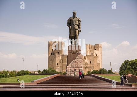 Statua di Amir Temur e sullo sfondo le rovine del Palazzo Ak-Saray a Shahrisabz nella provincia di Samarcanda Foto Stock