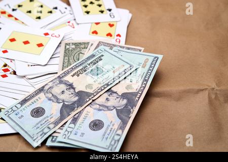 Un mucchio di dollari e un mazzo di carte da poker sparse su un tavolo Foto Stock