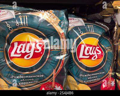 Bobruisk, Bielorussia - 2 gennaio 2025: Sacchetti colorati di spuntini dolci al caramello con mela sono ordinatamente disposti sullo scaffale, invitando gli acquirenti con il Foto Stock